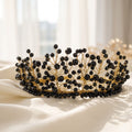 Handmade Black Majesty crown with faceted black beads and gold wire branches, displayed on soft ivory satin fabric.