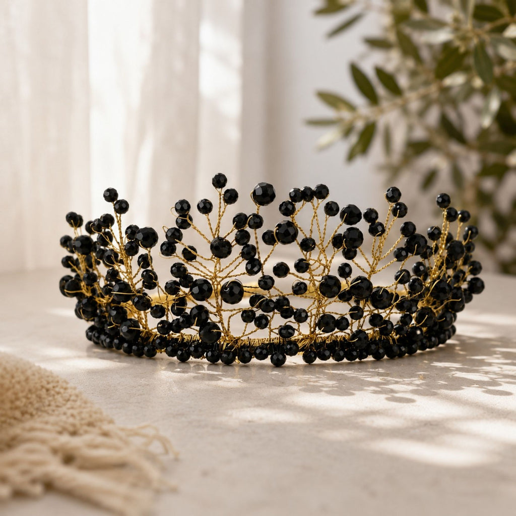 Handmade Black Majesty crown with faceted black beads and delicate gold wire branches, displayed in soft natural light with greenery in the background.