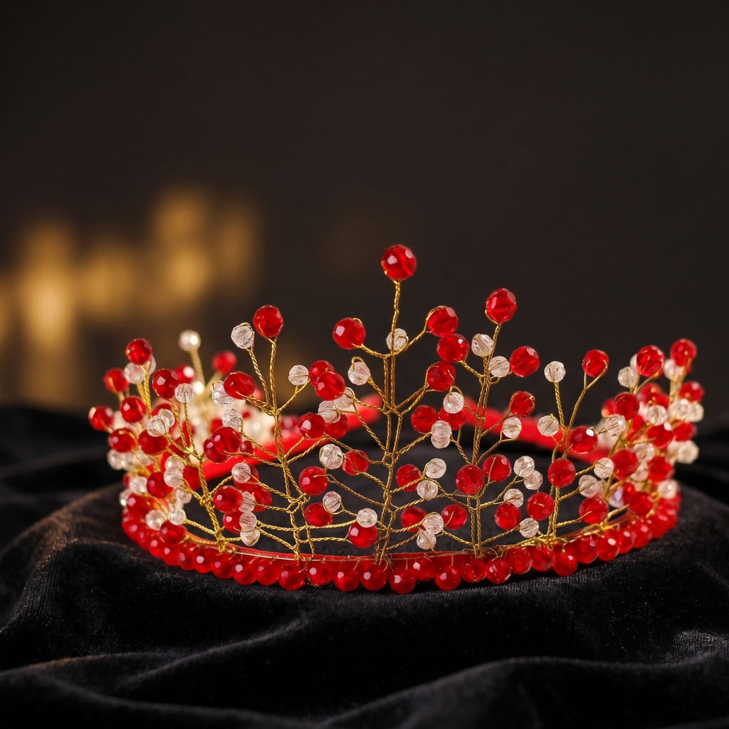 Handmade red and clear beaded crown with delicate gold wire branches, displayed on black velvet to highlight the sparkling crystal beads and elegant design.