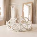 Handmade Ivory Dream pearl bridal crown with ivory pearls and clear crystal beads, displayed in an elegant bridal setting with a wedding dress and mirror.