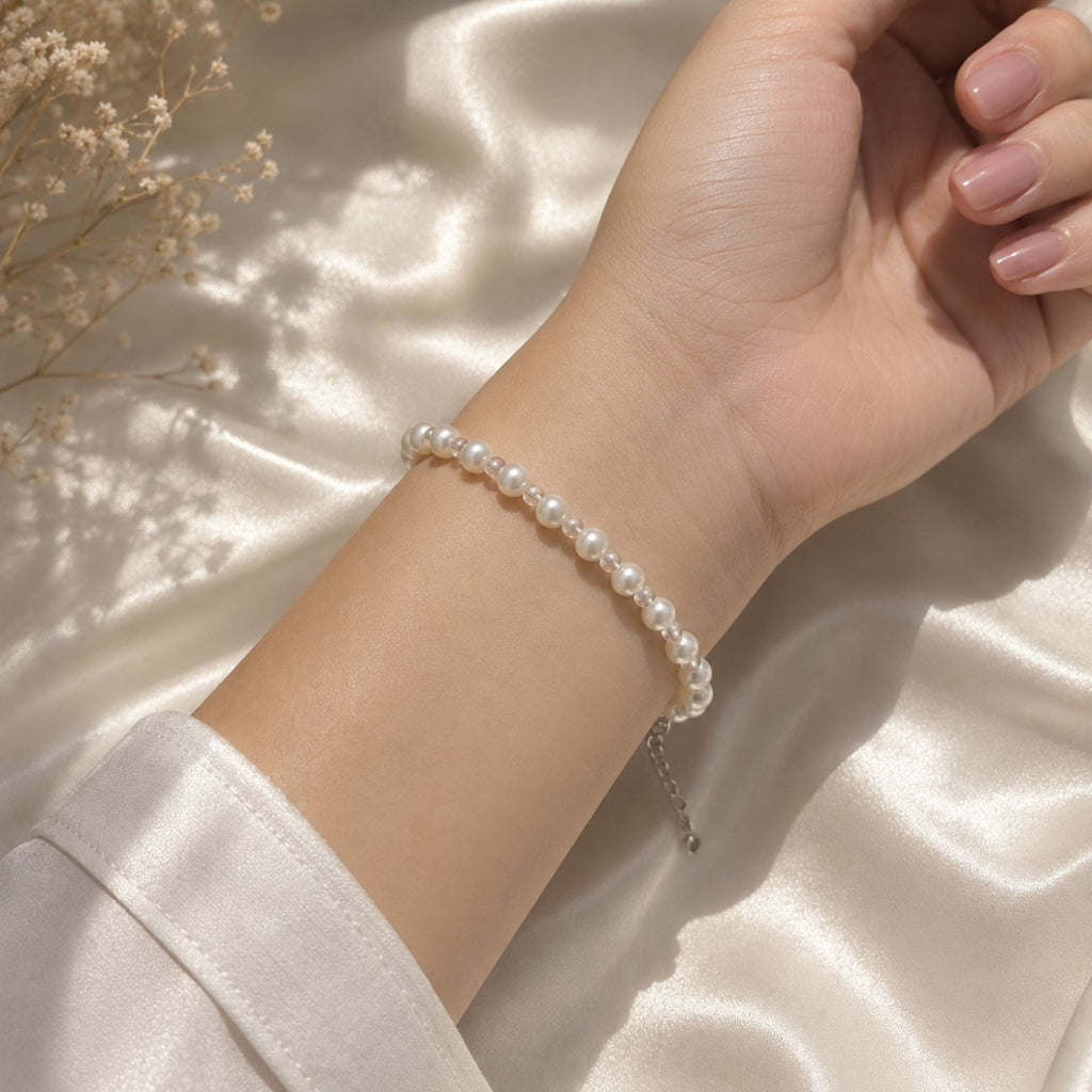 Lyra Moon white pearl bracelet worn on the wrist, featuring delicate transparent spacer beads and a silver-tone extension chain, elegant handmade jewelry for bridal, wedding and everyday looks.