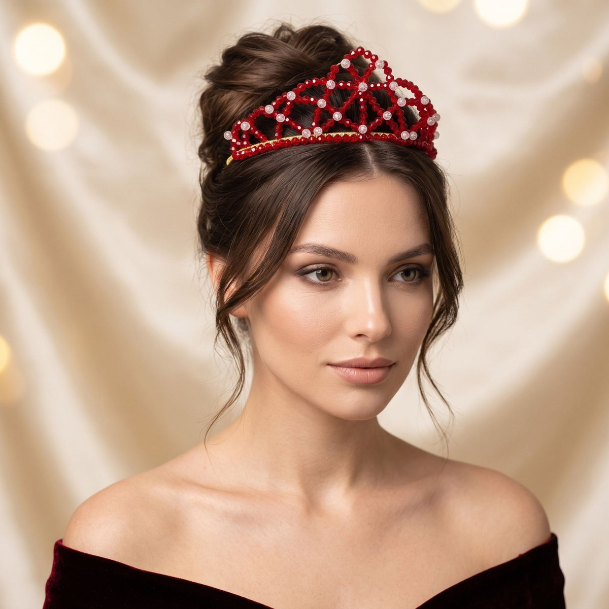 Elegant woman wearing the handmade Red Queen crown with faceted red glass beads, clear accent beads and gold-tone details, styled with an elegant updo.