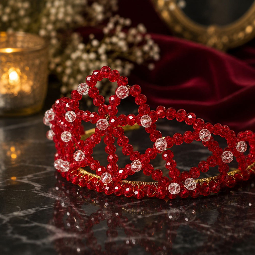 Handmade Red Queen crown with faceted red glass beads, clear accent beads and gold-tone details, elegantly displayed against burgundy velvet.